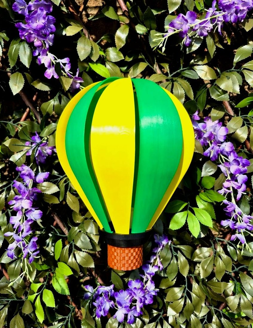 Hot air balloon wind spinner turning against garden foliage